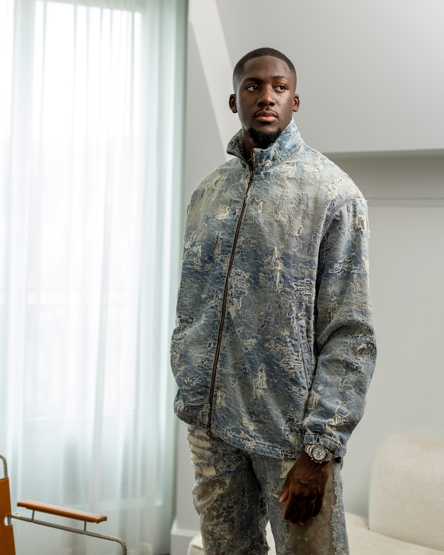 Ibrahima Konate looks dashing with a French romantic style in a denim outfit featuring white distressed accents